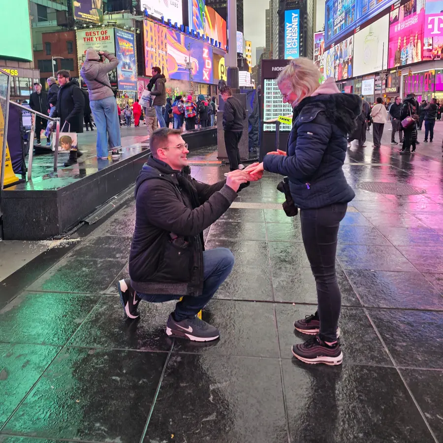 Timo kniet am Times Square in New York vor Janine und macht ihr einen Antrag.