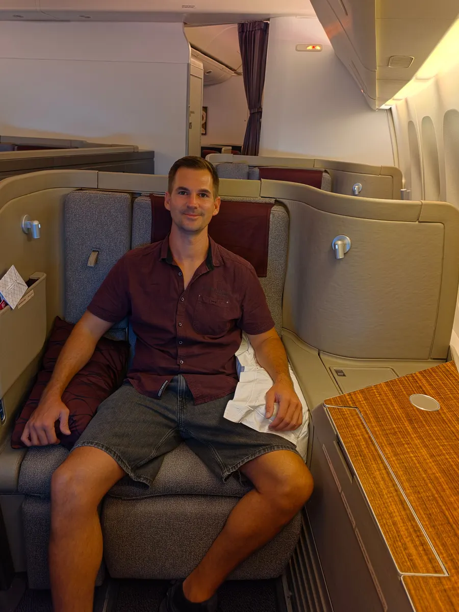 Timo sitzt lächelnd in seiner Kabine im Flugzeug